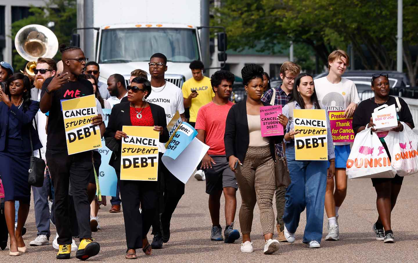 Two dozen people rally in from of the White House carrying signs to 