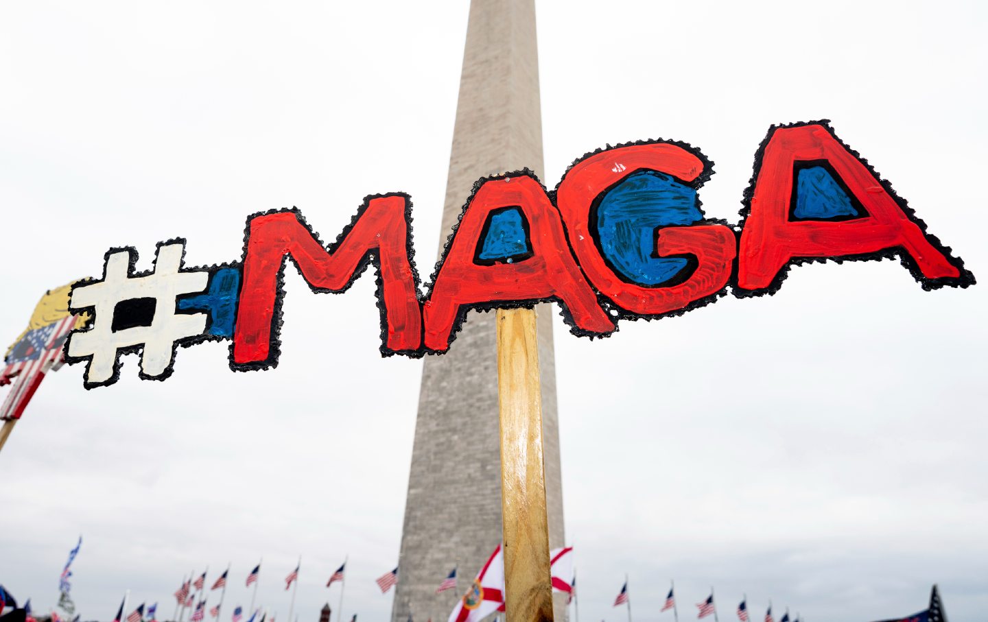 A MAGA sign in front of the Washington Monument at a Jan 6 Trump rally.