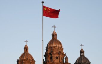 The Chinese national flag flies in front of the Wangfujing Catholic Church