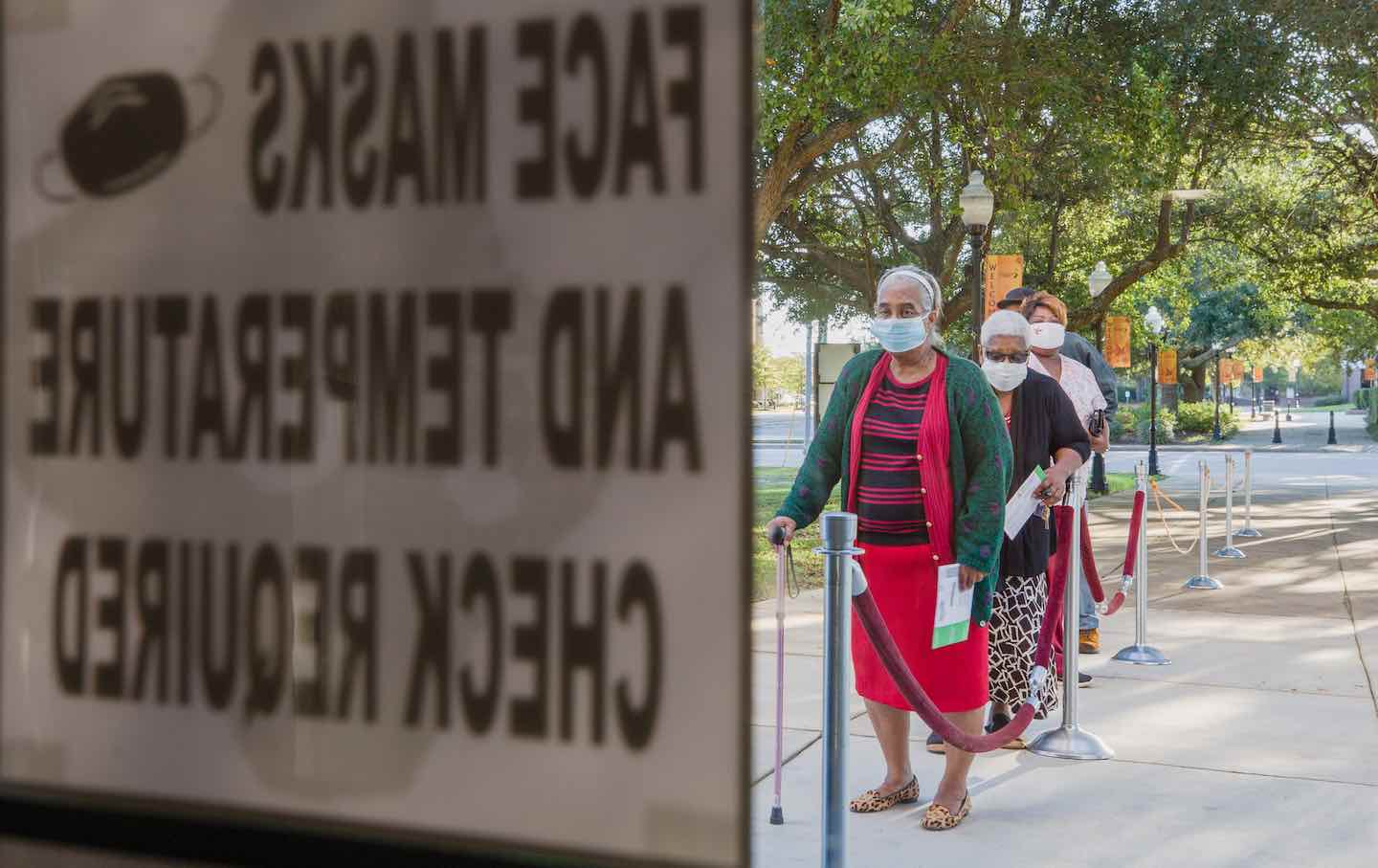 Residents wait in line outside an early voting polling location