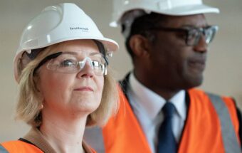 Prime Minister Liz Truss looks forward wearing a hard hat and safety glasses.