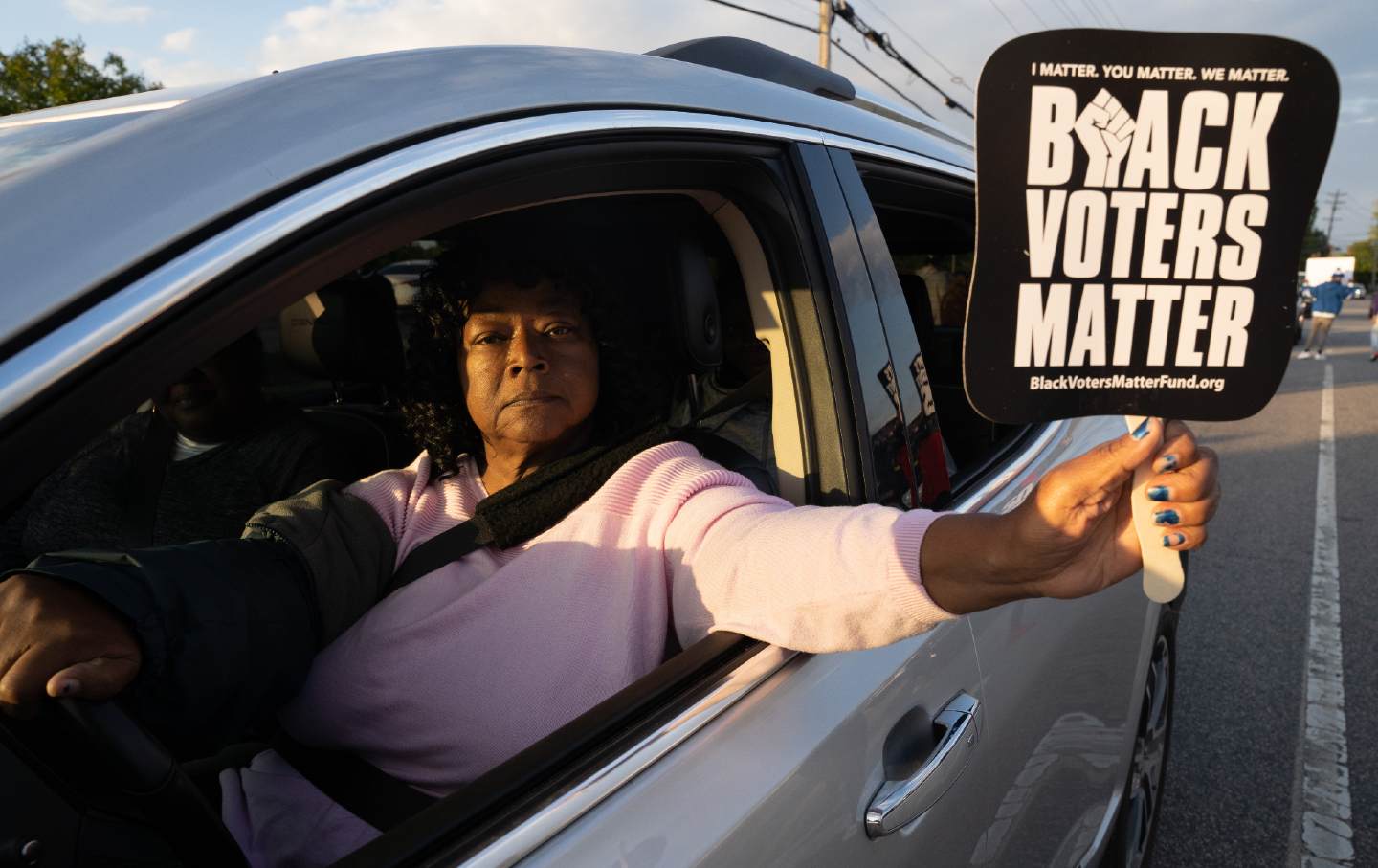 A woman holds a Black Voters Matter sign while driving in a protest march on April 22, 2021 in Elizabeth City, North Carolina.