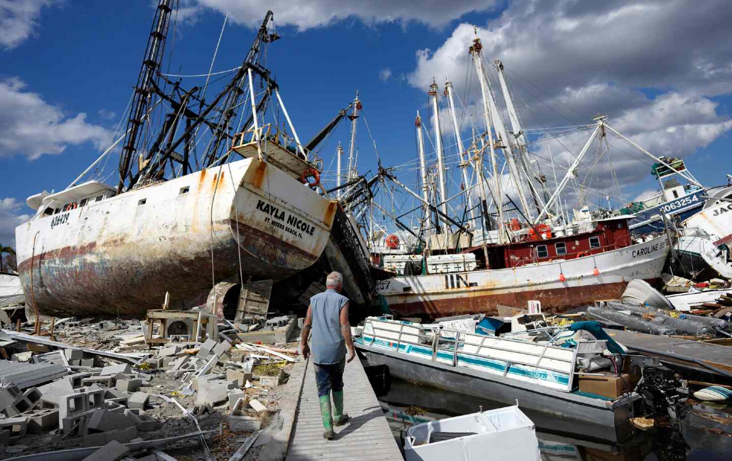 A week after Hurricane Ian, the waterfront of San Carlos Island, Florida is littered with debris from shrimp boats and a mobile home park.