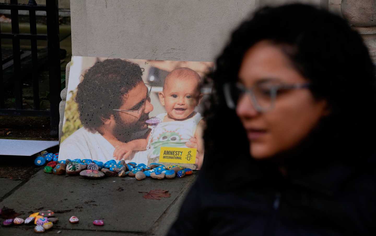Sanaa Seif stand in front of an image of her brother, the imprisoned pro-democracy activist Alaa Abdel-Fattah.