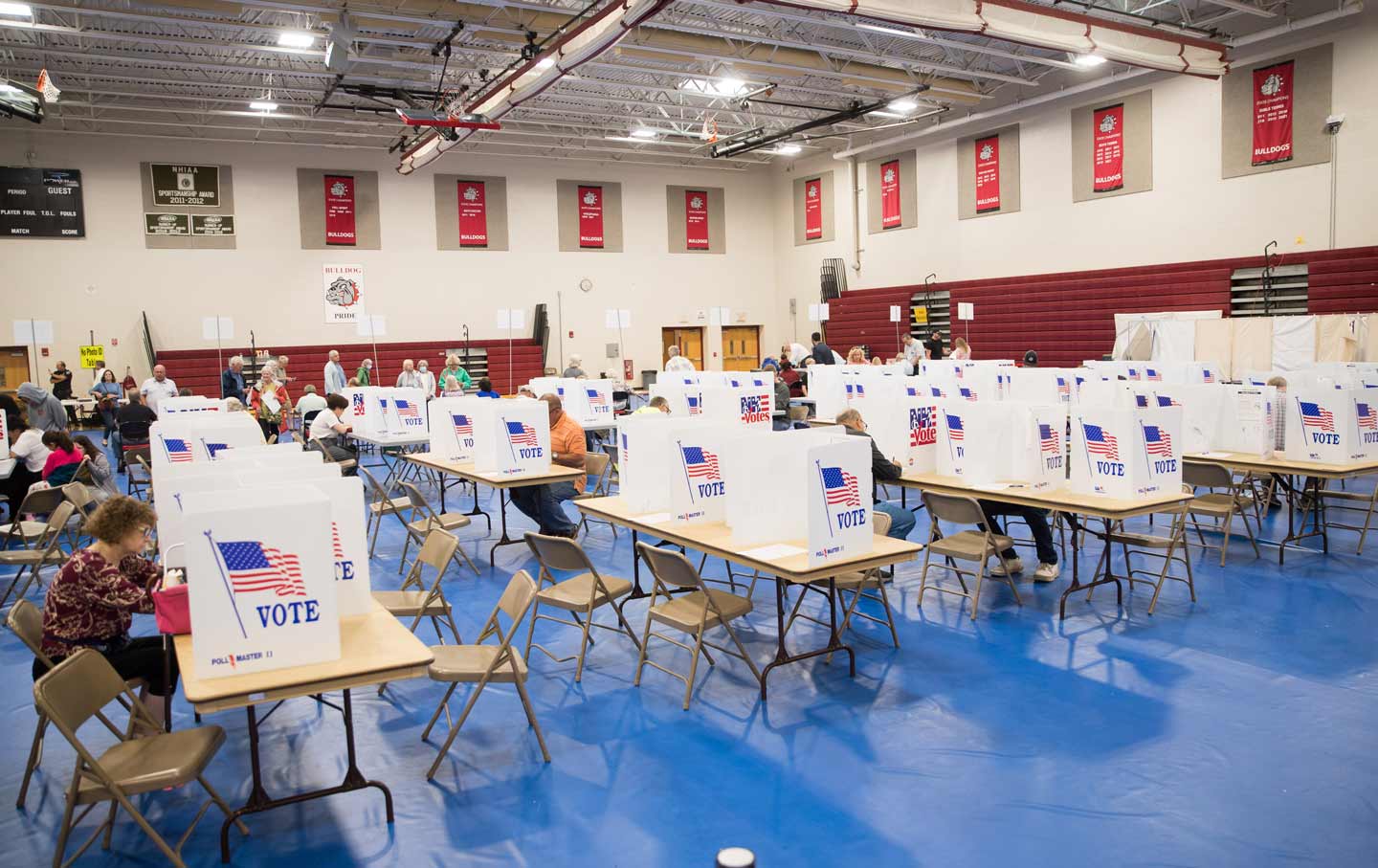 New Hampshire voters at voting booths in a gymnasium