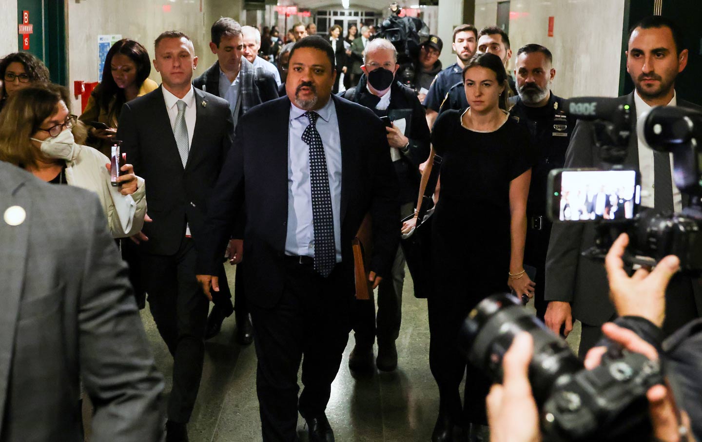 Alvin Bragg walking through a corridor after a guilty verdict in the Trump organization prosecution