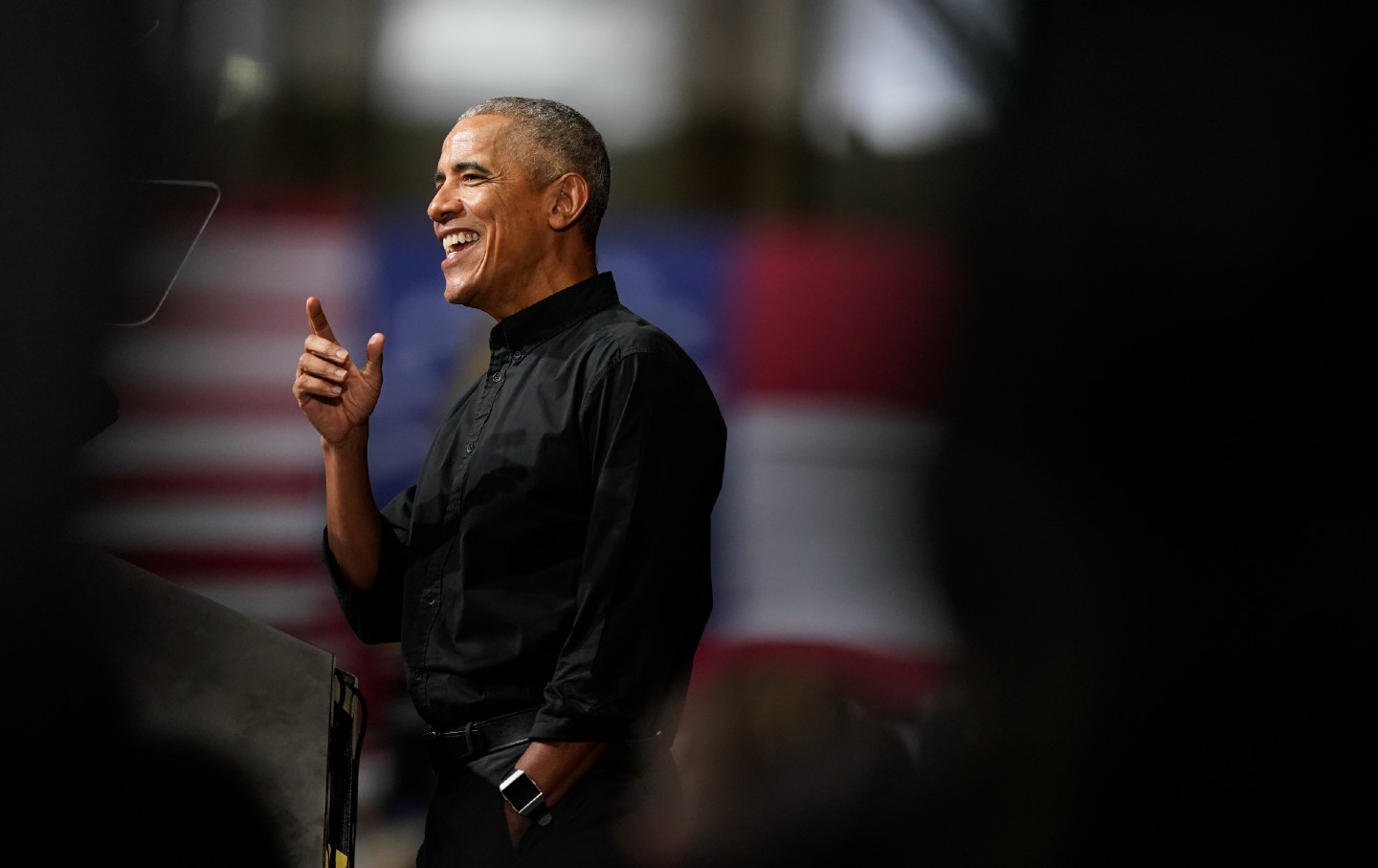 Barack Obama smiling and speaking at an Atlanta rally in support of Senator Raphael Warnock.