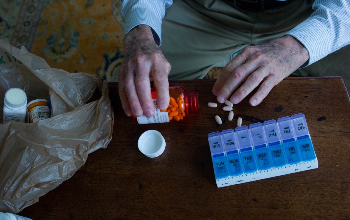 Charles Miller, 90, prepares the daily pills his wife needs in early 2020.