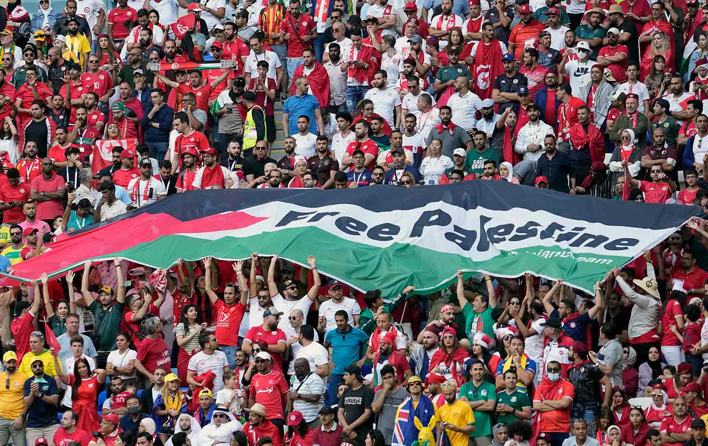 Soccer fans unfurl a flag that reads Free Palestine at the World Cup in Qatar.