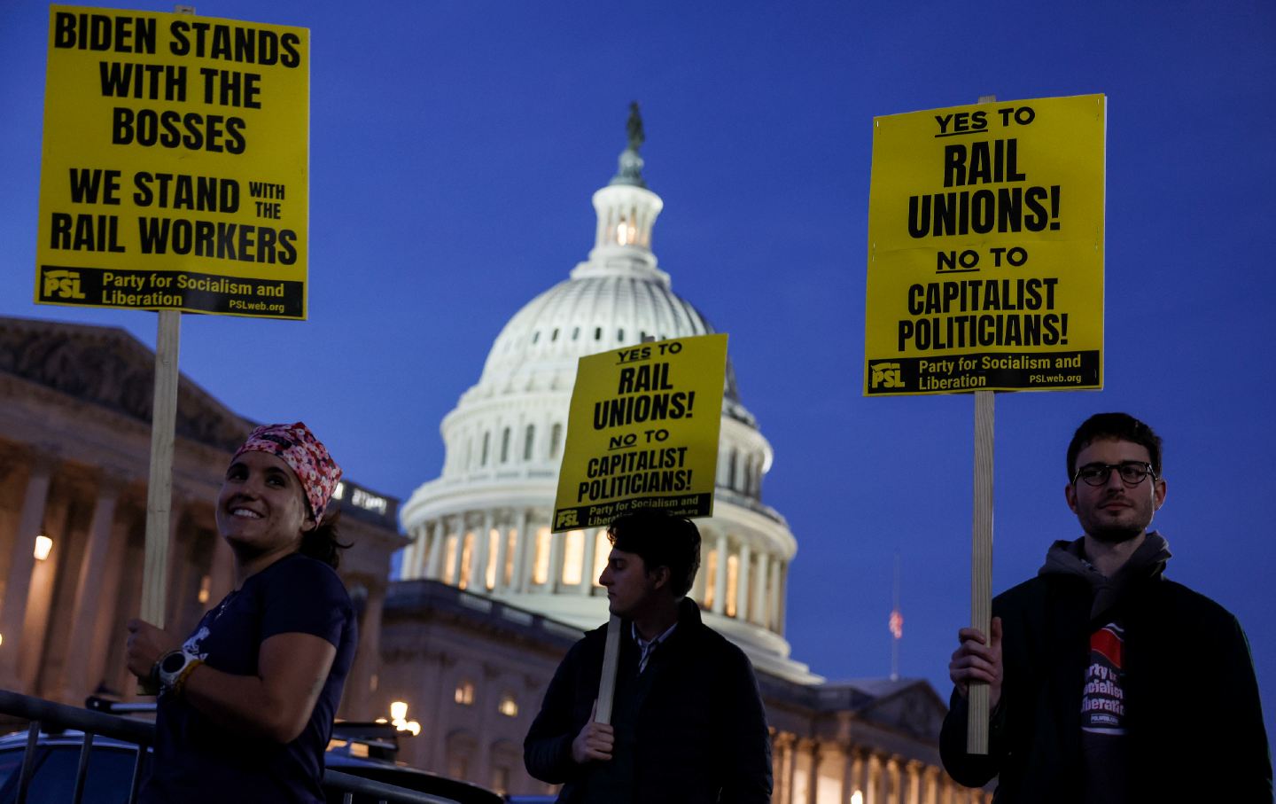 Activists rally with signs in support of unionized rail workers outside the Capitol.