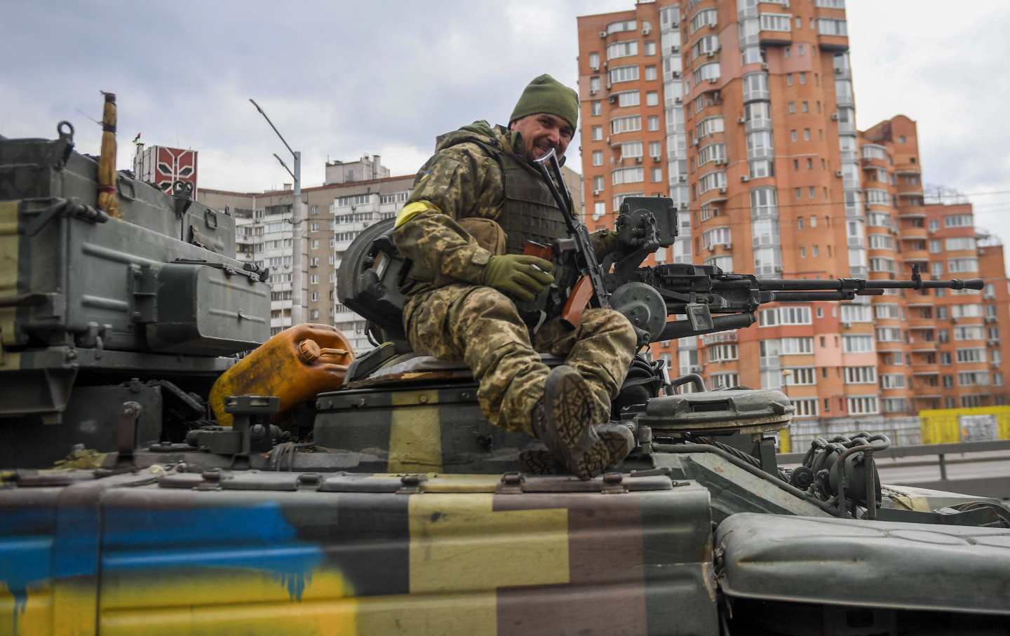 Ukrainian soldier sits on top of a tank.