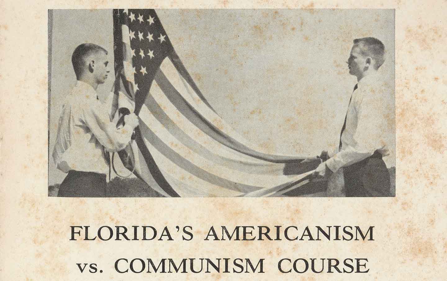 Two boys with crew cuts raise an American flag