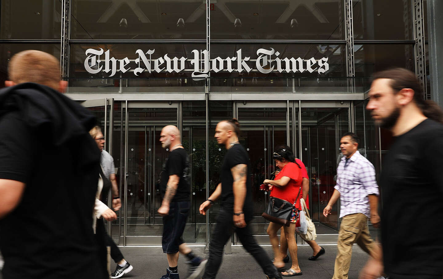 People walk past the New York Times building
