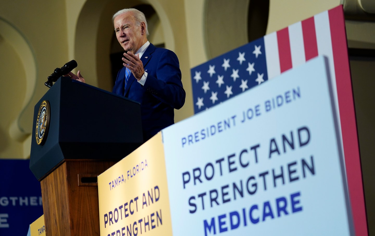 Biden at a dais flanked by signs saying 