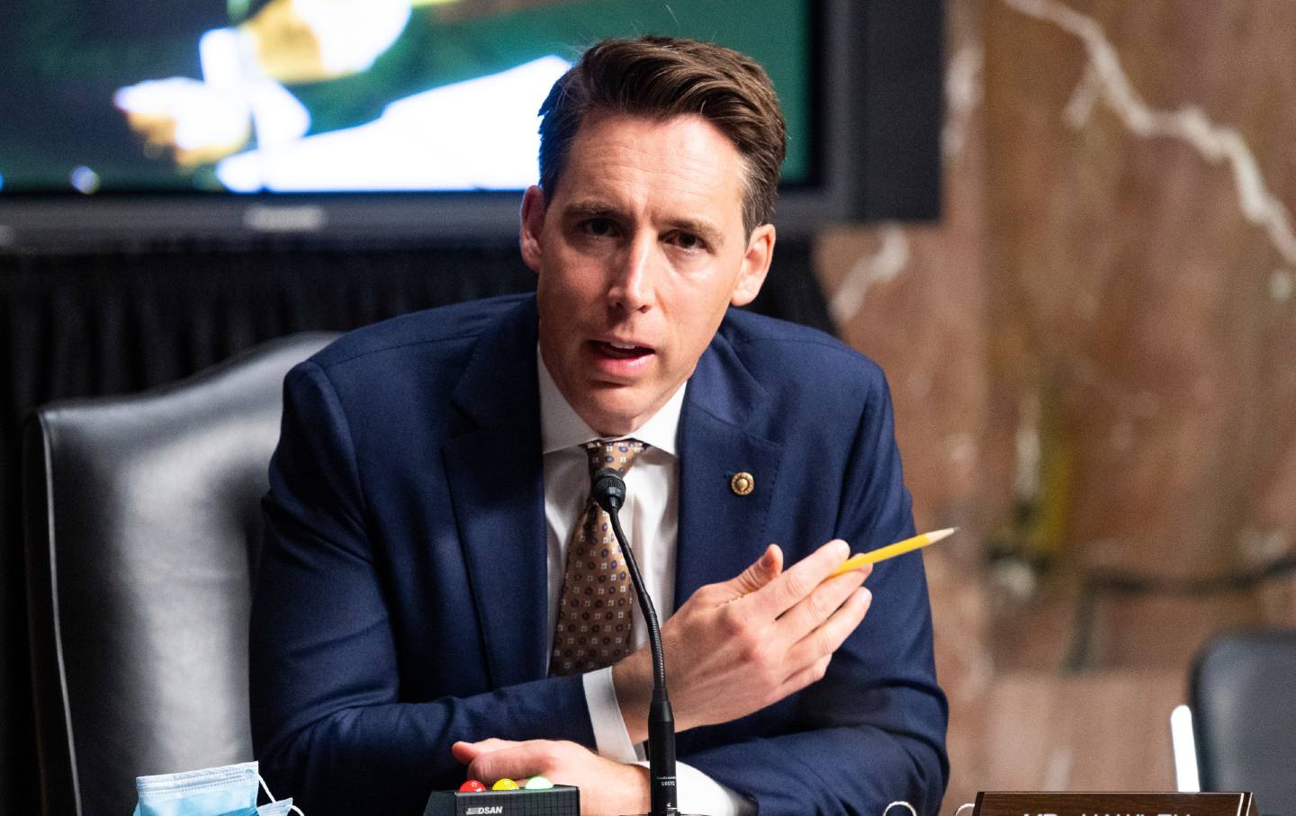 Josh Hawley holding pencil in front of microphone