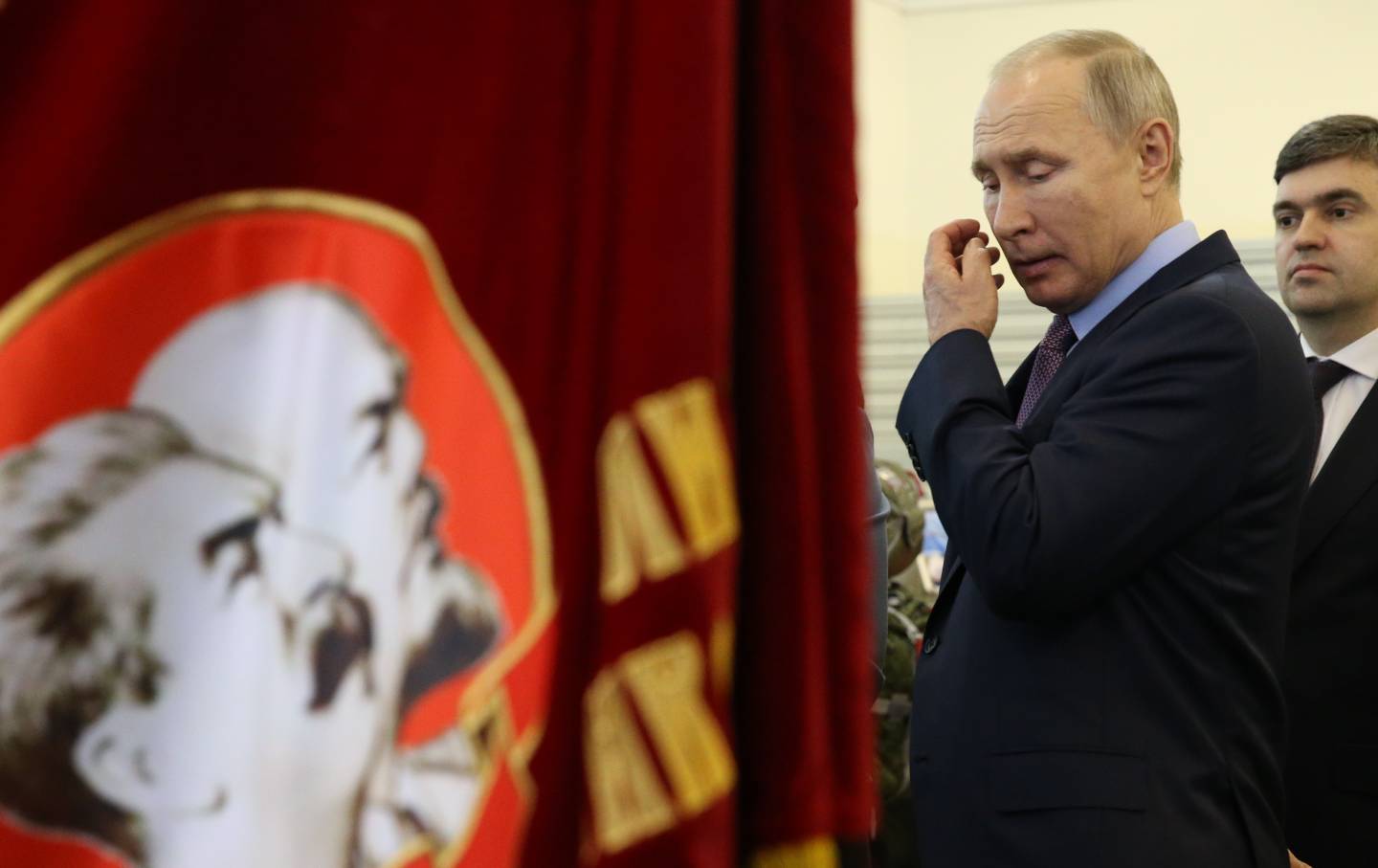 Russian President Vladimir Putin looks on the flag with portraits of Soviet leaders Vladimir Lenin and Joseph Stalin while visiting the Parachute factory in Ivanovo, Russia on March 6, 2020.
