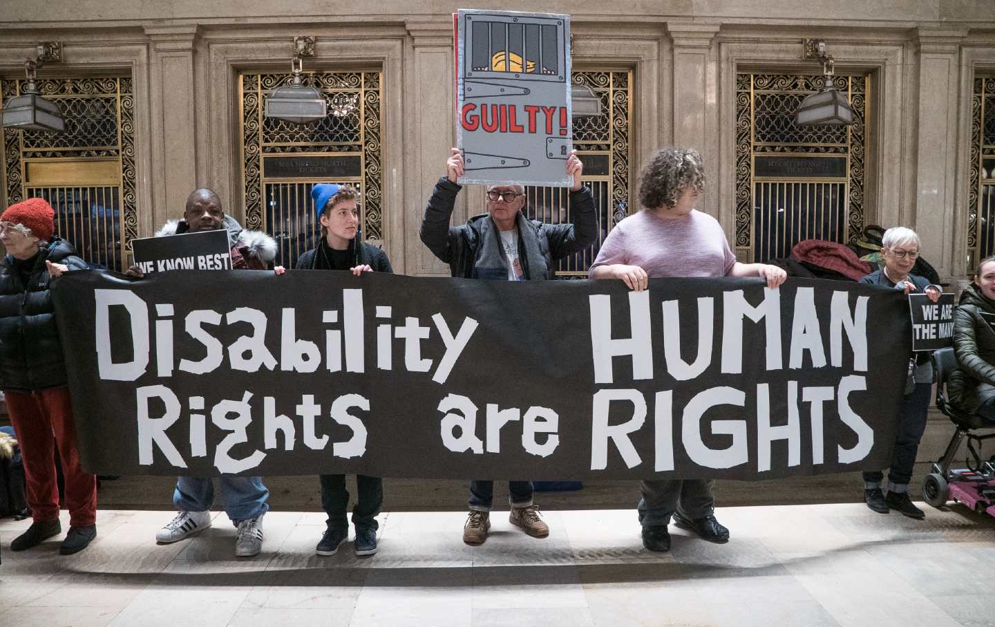 Demonstrators holding a banner that reads “Disability Rights are Human Rights”