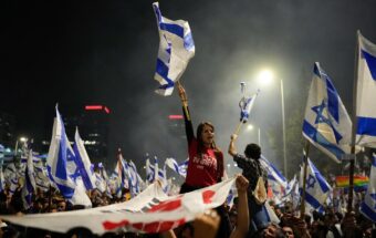 Israelis hold flags at a protest