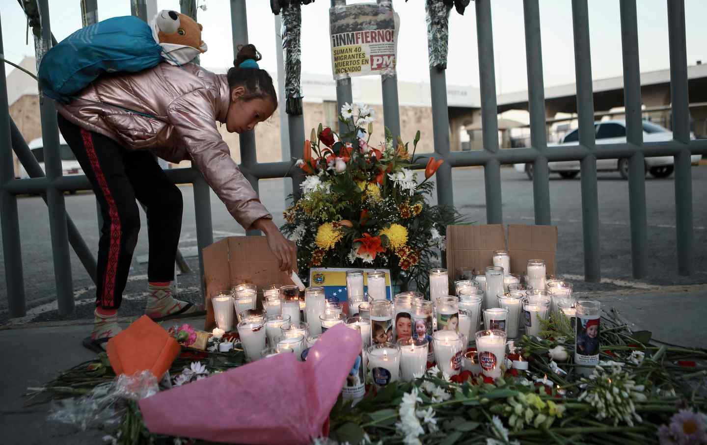 A girl lights a candle at a vigil