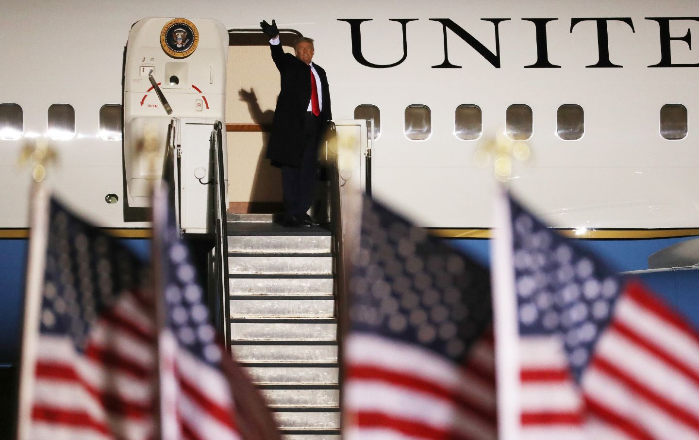 Former President Donald Trump waves from the steps of Air Force One