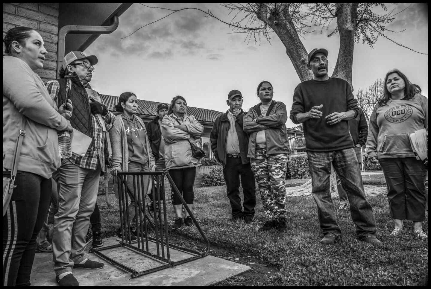 Lidia Torres and other evicted farmworkers listen to Hector Hernandez of the Unidad Popular Benito Juarez, outside a meeting of the Tulare County Housing Authority.