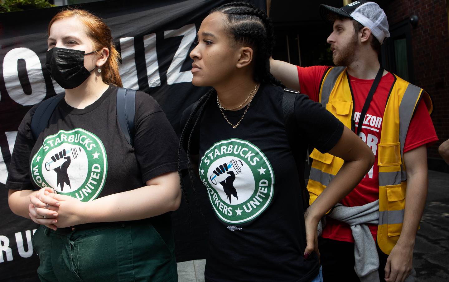 Starbucks workers hold a banner