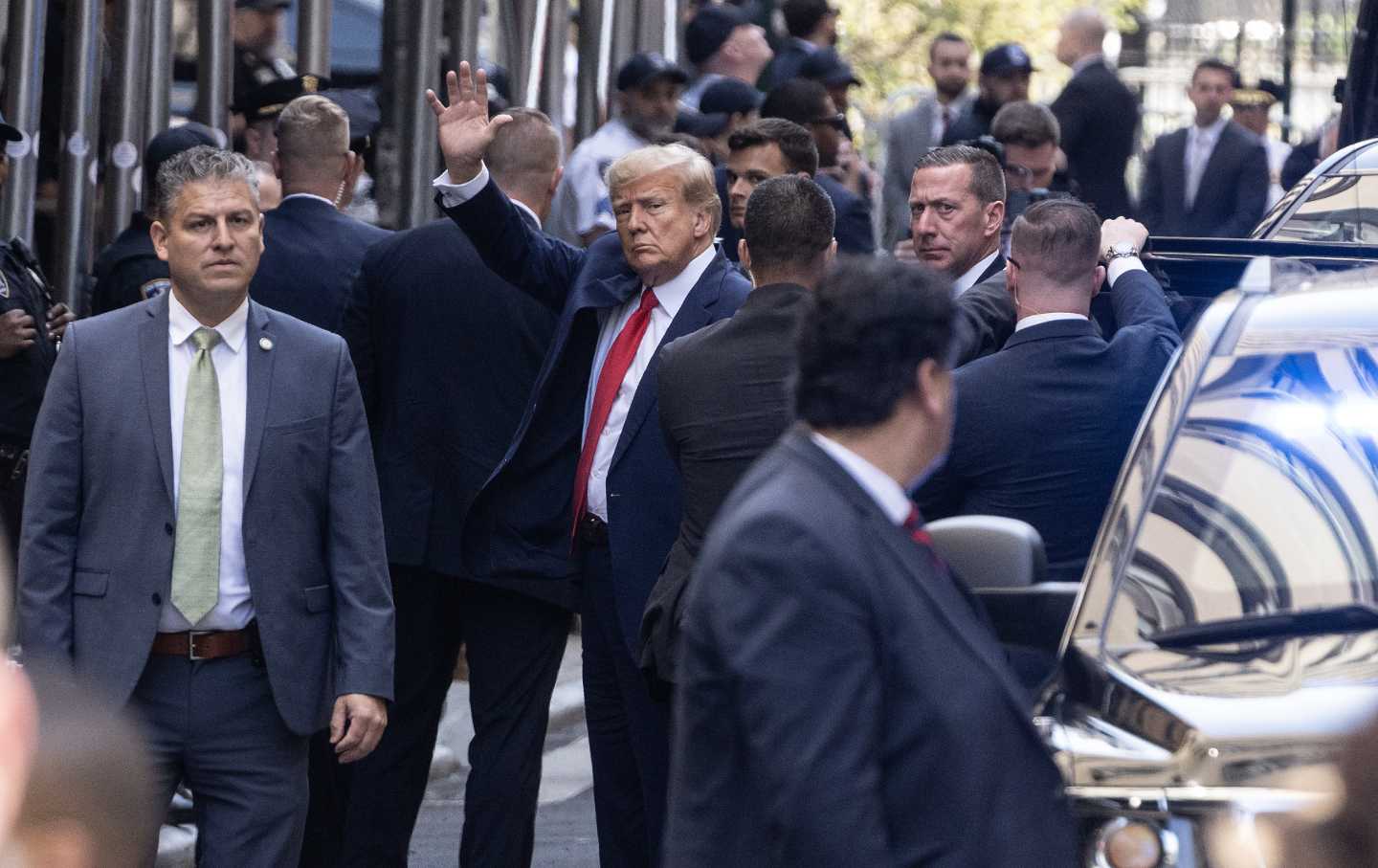 Donald Trump waves to the crowd outside the New York criminal courthouse.