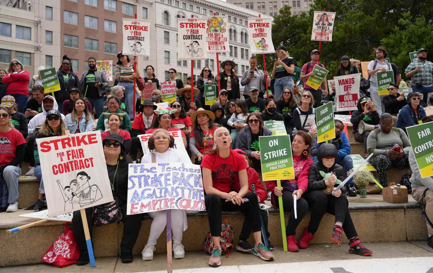 Striking teachers hold a rally outside City Hall in Oakland, Calif.