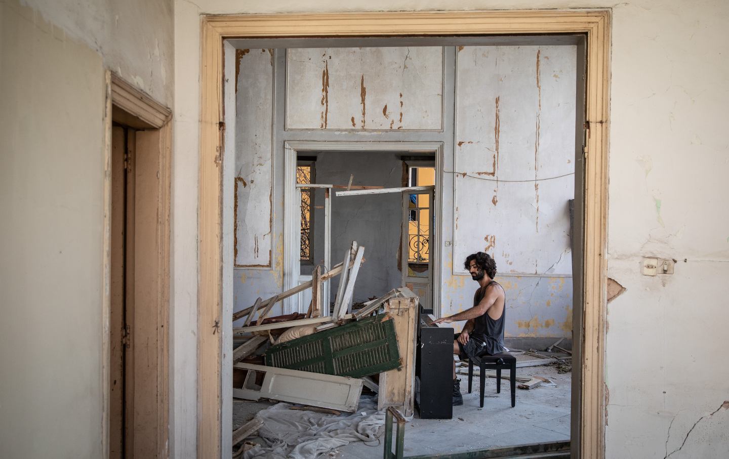 Artist and musician Raymond Essayan plays a piano he sculpted from the rubble of a destroyed building