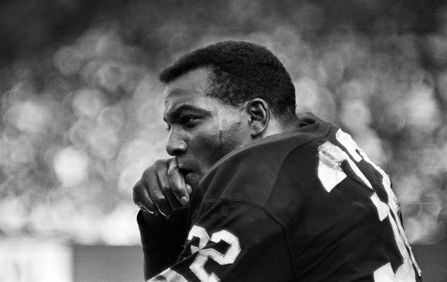 Jim Brown sits on the sideline, his helmet off.