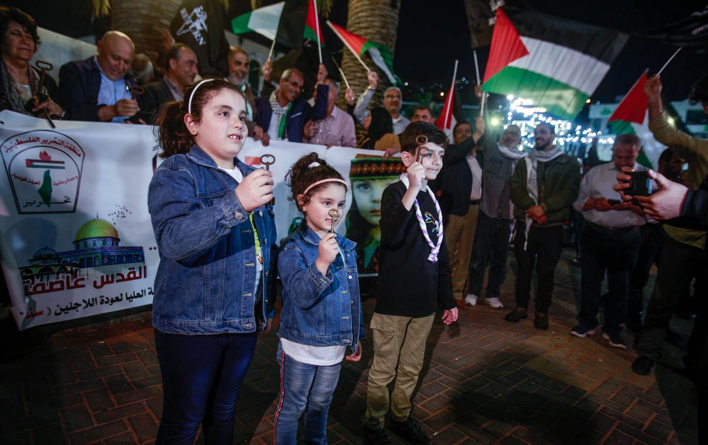 Palestinian kids hold keys in their hands to mark the 75th anniversary of the Nakba