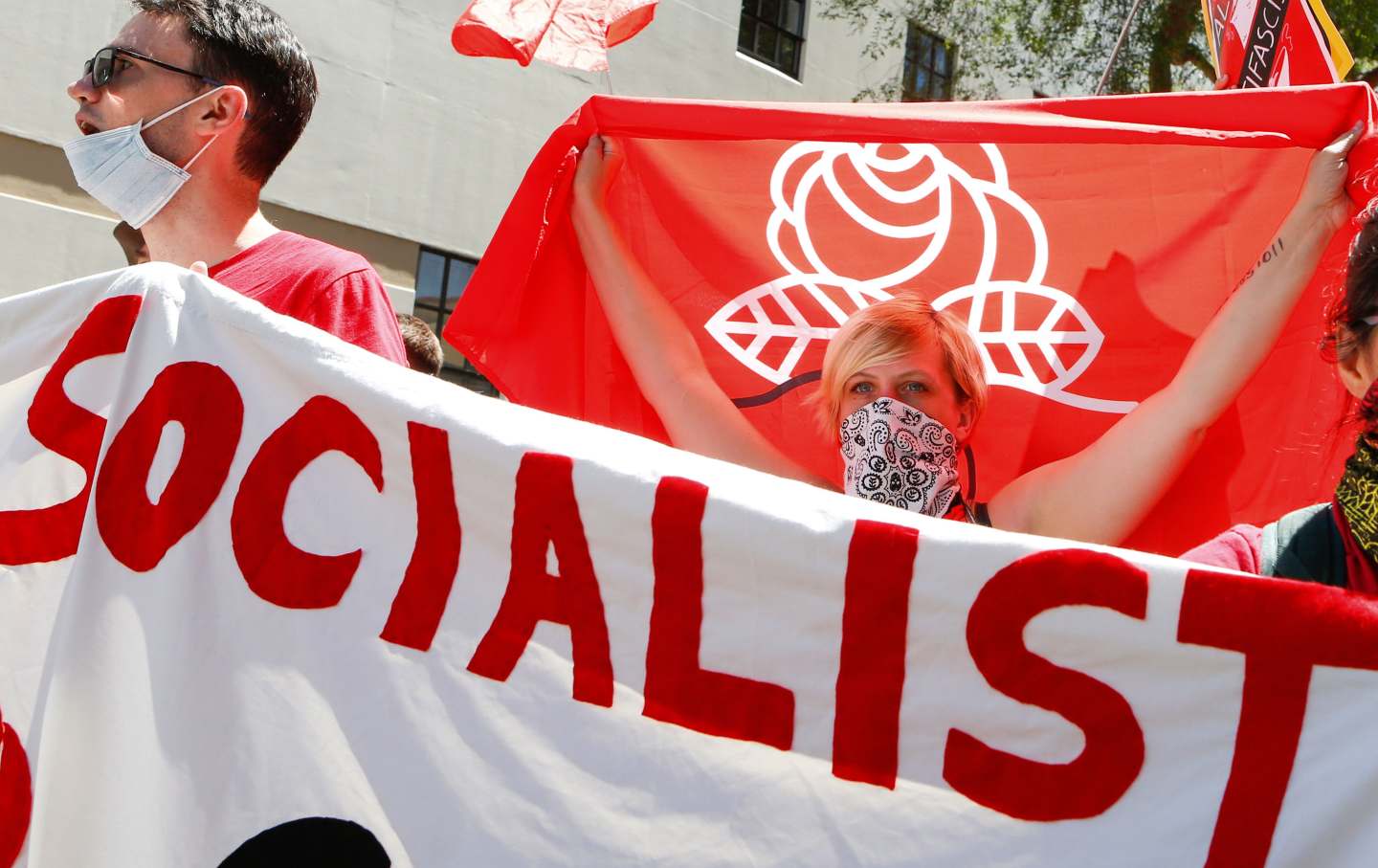 Democratic Socialists of America counter protesters hold signs and flags as they march, protesting an alt-right rally on August 5, 2018 in downtown Berkeley, California.