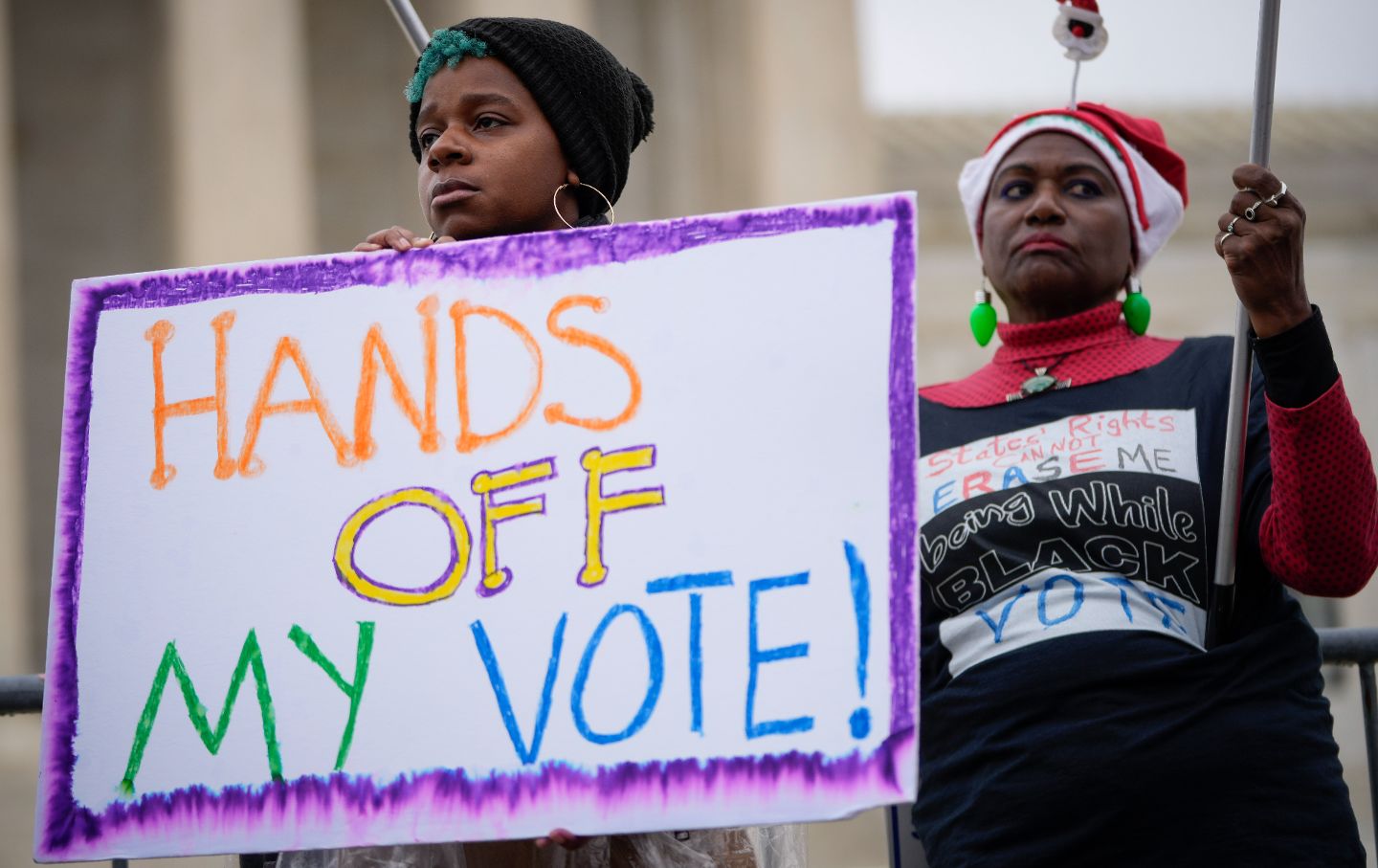 A protester holds a sign reading 'HANDS OFF MY VOTE' at a rally outside the Supreme Court on December 7, 2022.