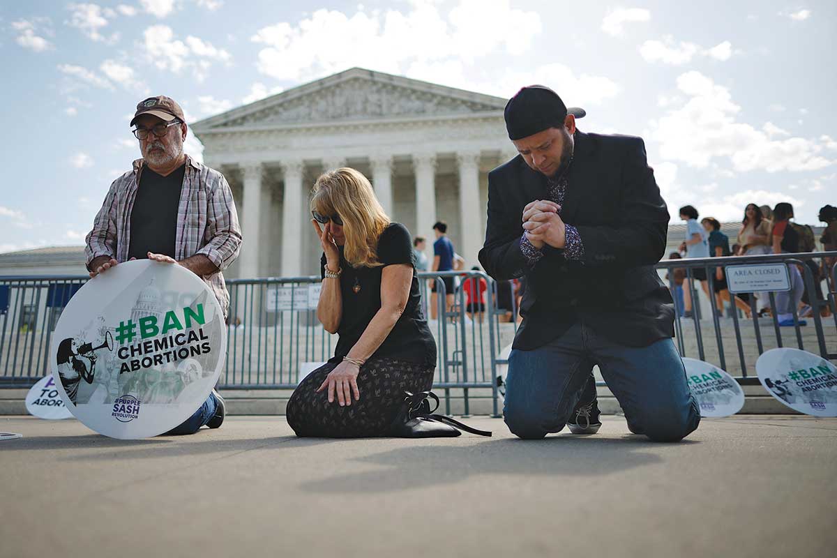 Mark Lee Dickson, one of the activists pushing anti-abortion ordinances in New Mexico, prays in front of the Supreme Court.