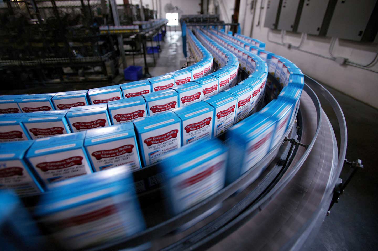 Boxes of cake mix on packing line in factory (blurred motion)