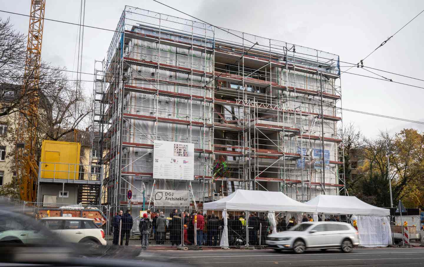 Visitors, employees, and future residents stand at the topping-out ceremony for a residential building in Frankfurt, Germany.