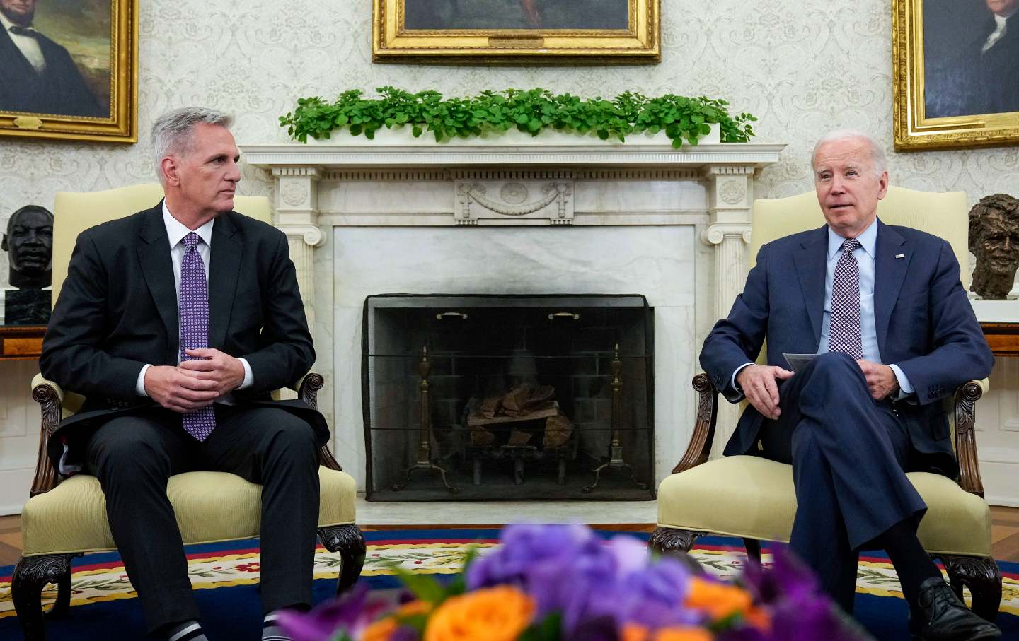 Biden and McCarthy sitting in chairs in the Oval Office