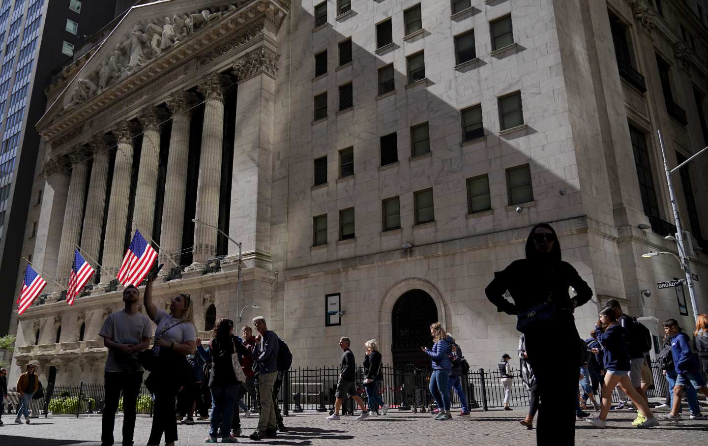 Visitors walk past the New York Stock Exchange