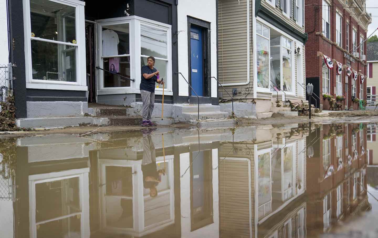 Kathy Eason, a worker at the Center for Highland Falls, stands outside the organization's storefront after being trapped inside by floodwaters the previous day, Monday, July 10, 2023, in Highland Falls, N.Y.