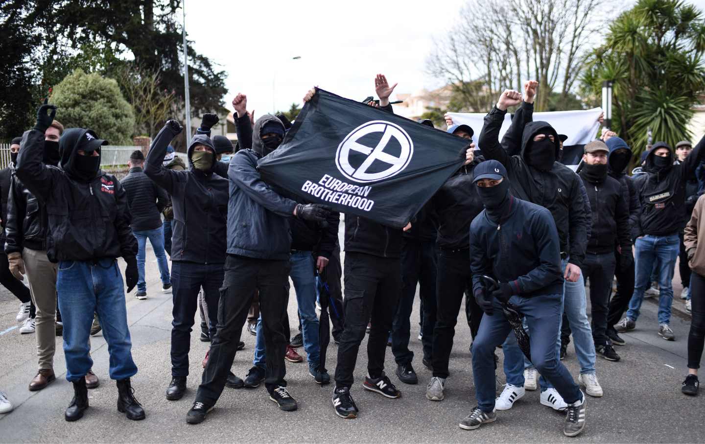 Far right 'European Brotherhood' protesters hold a banner as they pose at a rally in Saint-Brevin-les Pins, western France on February 25, 2023, held to protest against the establishment of a reception center for migrants.