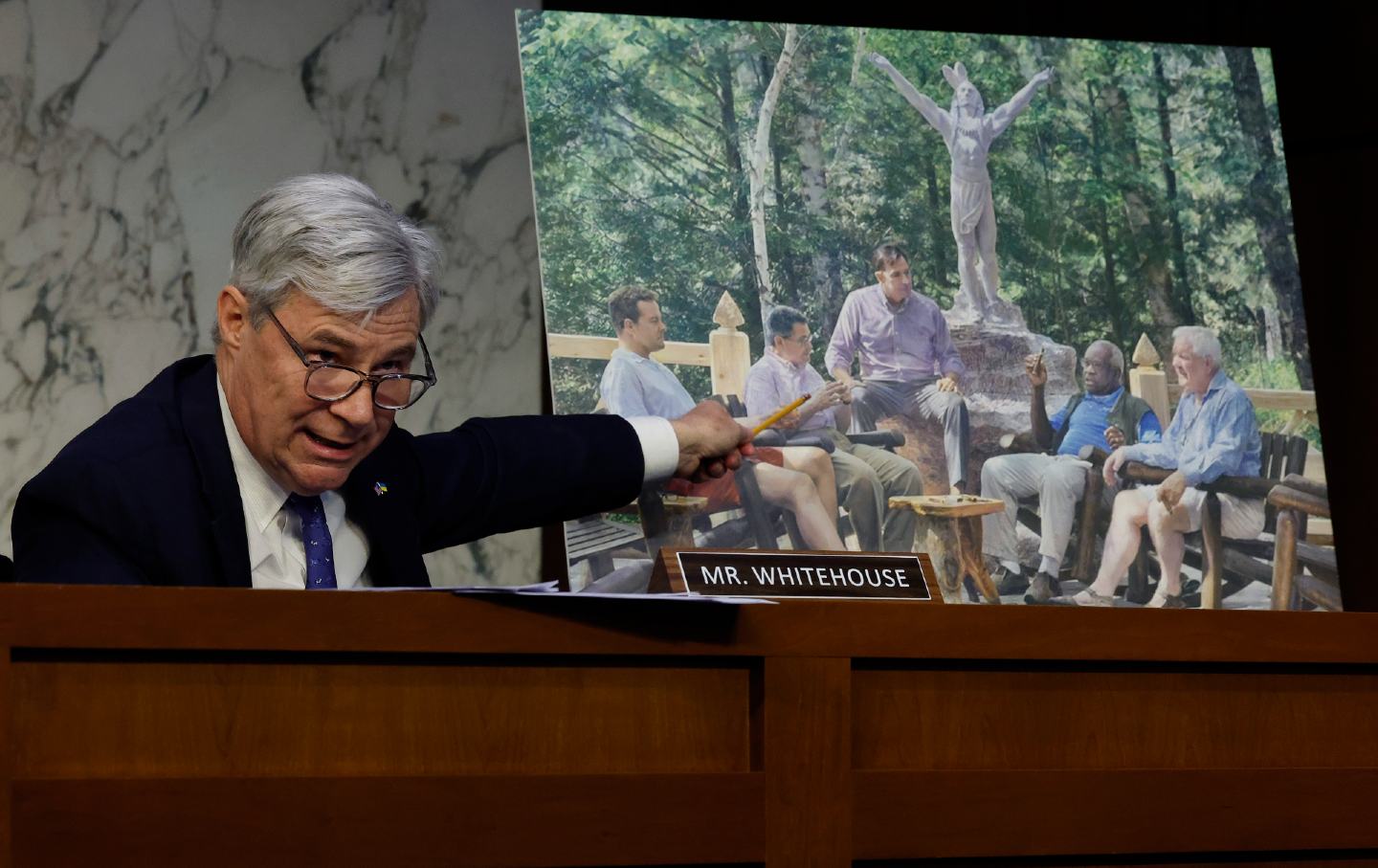 Senate Judiciary Committee member Senator Sheldon Whitehouse (D-R.I.) displays a copy of a painting featuring Supreme Court Associate Justice Clarence Thomas alongside Harlan Crow and other conservative friends during a hearing on Supreme Court ethics reform.
