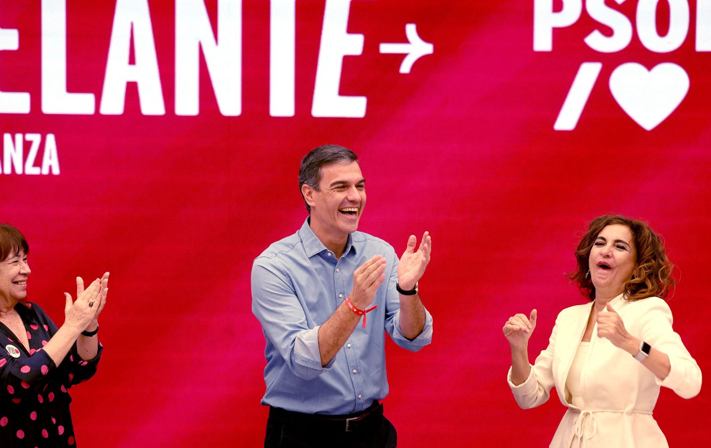 Spanish Prime Minister Pedro Sanchez applauds next to Spain's Minister of Budget Maria Jesus Montero (R) and PSOE President Cristina Narbona at the Spanish Socialist Party (PSOE) headquarters in Madrid on July 24, 2023.