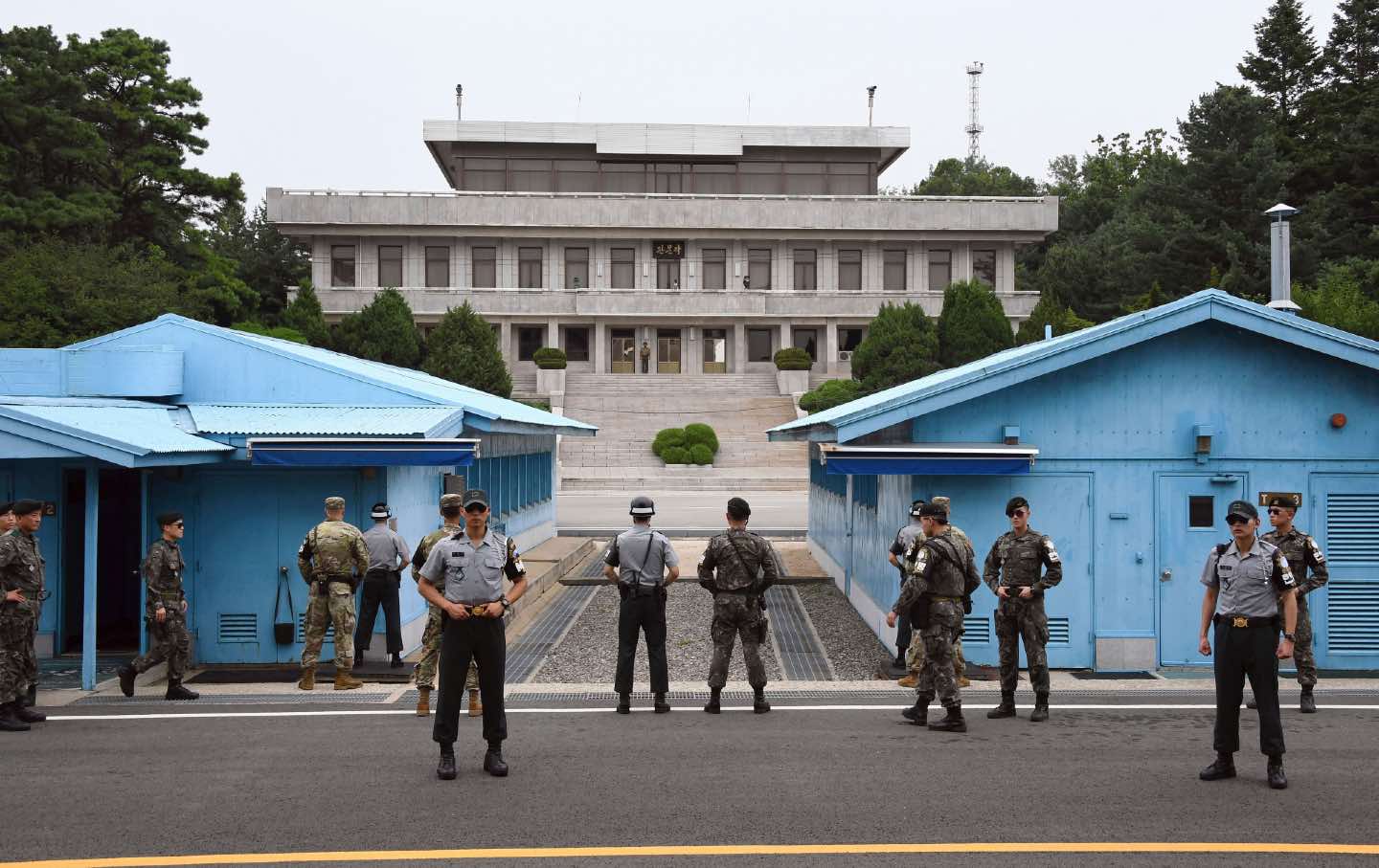 South Korean and US soldiers stand outside outside in the demilitarized zone between North and South Korea