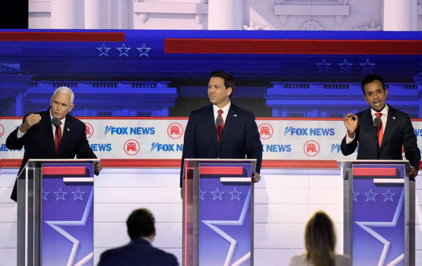 Florida Governor Ron DeSantis listens as former vice president Mike Pence and businessman Vivek Ramaswamy talk at the same time during a Republican presidential primary debate hosted by the Fox News Channel on Wednesday, Aug. 23, 2023, in Milwaukee.