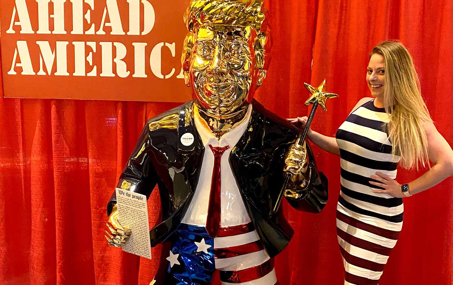 Amanda Moore poses with a Donald Trump statue at the Conservative Political Action Conference in Orlando, Fla.