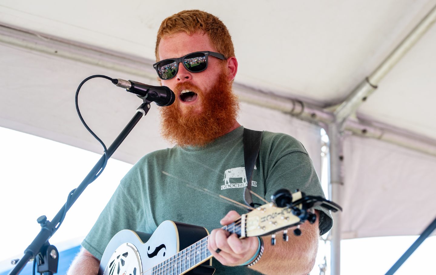 photo of oliver anthony singing, holding guitar