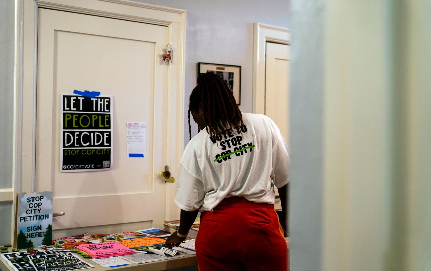 Volunteer Rojauna McPherson looks at a table full of pamphlets after being trained as a new volunteer at one of the 