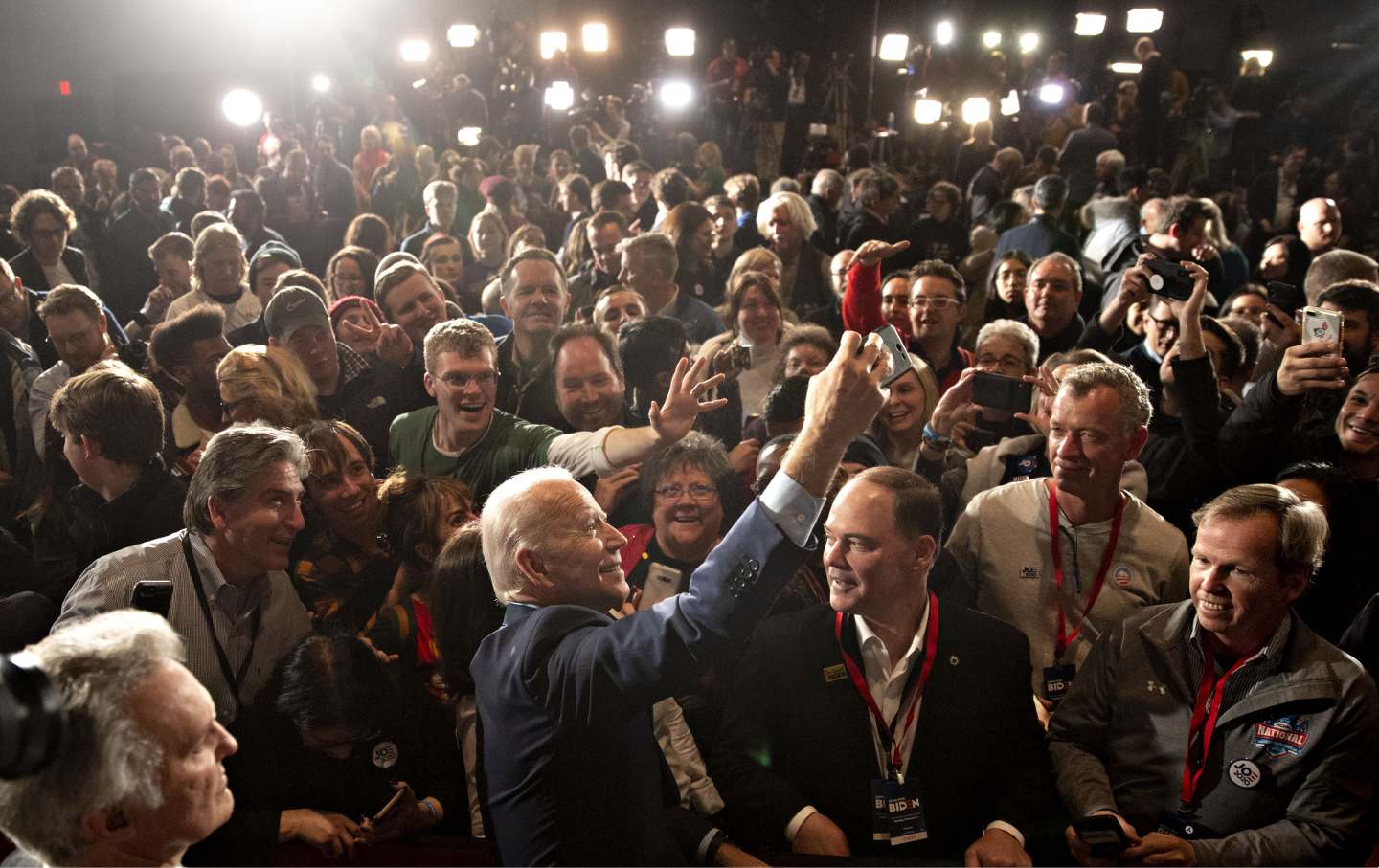Joe Biden, 2020 Democratic presidential candidate, center, takes a 'selfie' photograph with supporters during a caucus night watch party in Des Moines, Iowa, U.S. on Monday, Feb. 3, 2020.