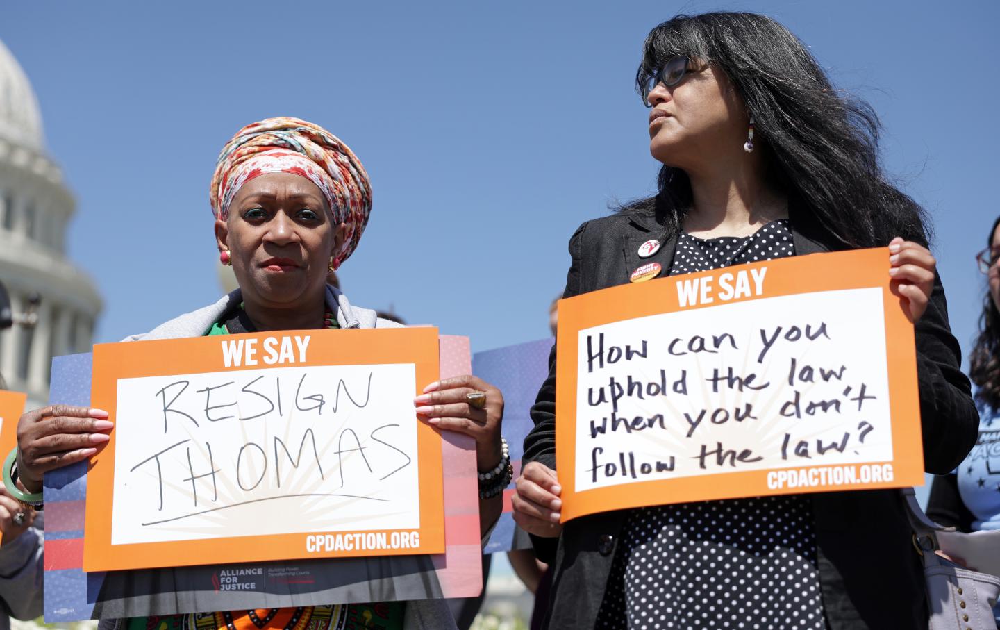 During an April 19, 2023, news conference outside the US Capitol, activists hold signs calling for the immediate resignation of Supreme Court Associate Justice Clarence Thomas.