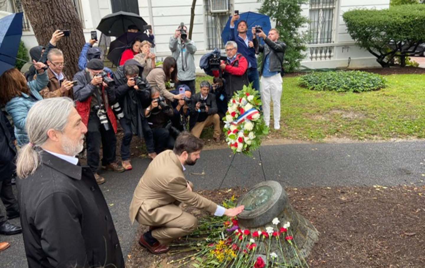 Boric kneeling at monument for Letelier and Karpen Moffitt